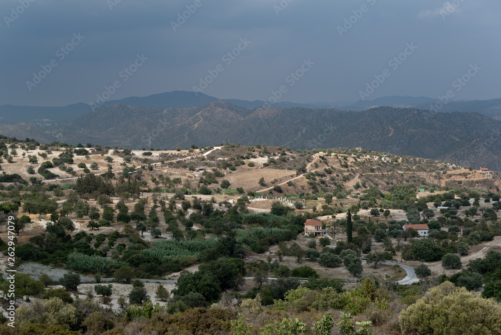 Aerial view of small beautiful village. View of mountains and storm clouds. Summer.