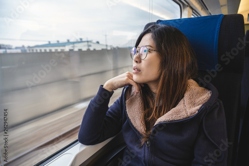 Canvas Print Asian Young lady passenger Sitting in a depressed mood beside the window inside