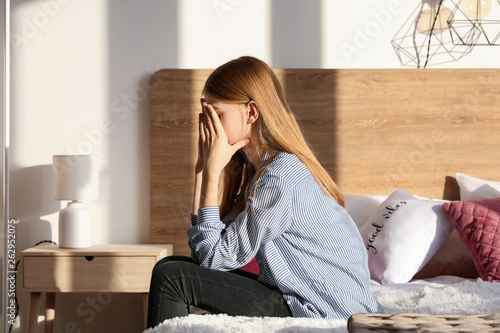 Sad teenage girl sitting on...