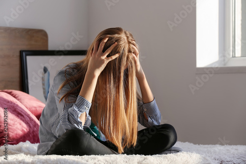 Sad teenage girl sitting on...