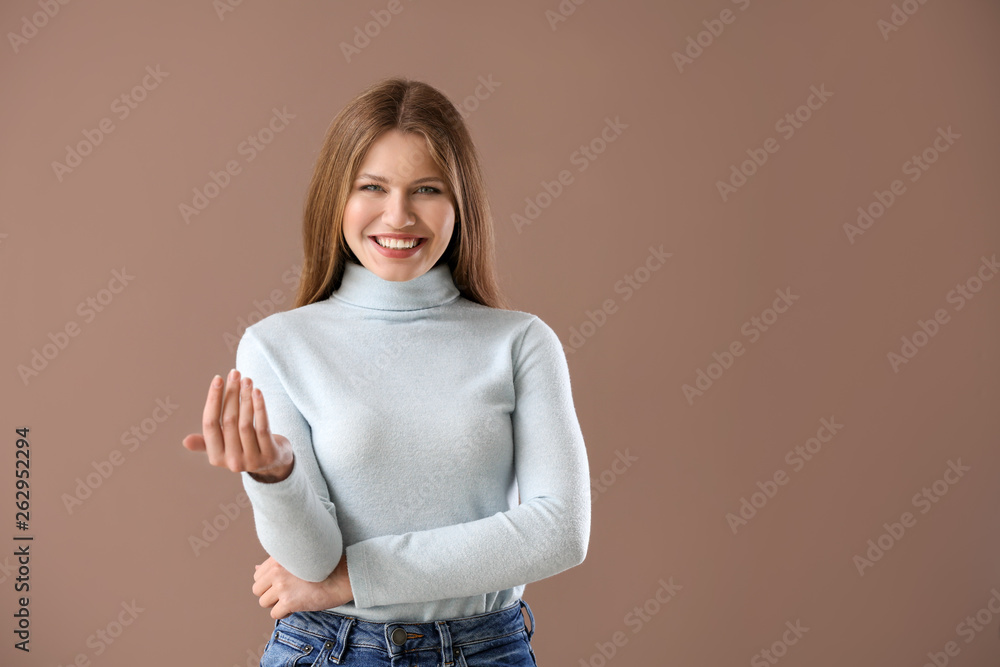 Beautiful young woman inviting viewer against color background Beautiful young woman inviting viewer against color background