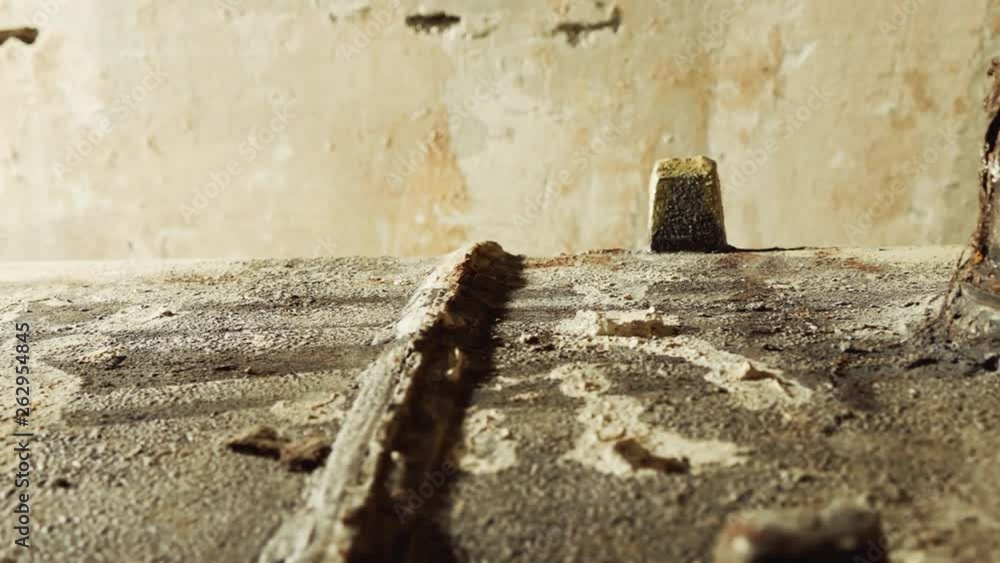 Old rusty cast-iron upside down bath against background of concrete wall with stripped wallpaper in room in process of overhaul of the house. Old rusty cast-iron upside down bath against background of concrete wall with stripped wallpaper in room in process of overhaul of the house.