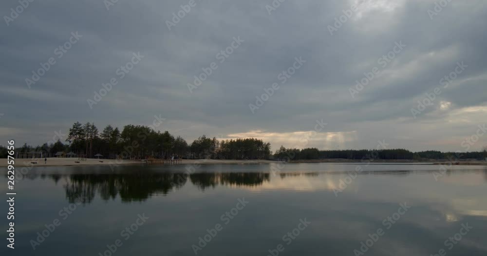 Beautiful forest lake at sunset spring day. Storm clouds slowly float above the lake.Time Lapse. Beautiful forest lake at sunset spring day. Storm clouds slowly float above the lake.Time Lapse.