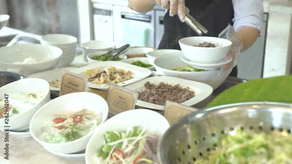 Cook putting food in bowl in buffet while lunch in all inclusive resort hotel restaurant. Restaurant food for traditional brunch, lunch and dinner in luxury hotel. Cook putting food in bowl in buffet while lunch in all inclusive resort hotel restaurant. Restaurant food for traditional brunch, lunch and dinner in luxury hotel.