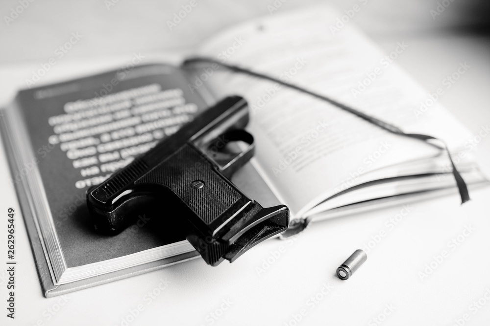 Detective novel concept with gun, book and bullet. Black and white photo. Detective novel concept with gun, book and bullet. Black and white photo.