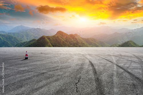 Asphalt race track ground and mountain with sunset clouds