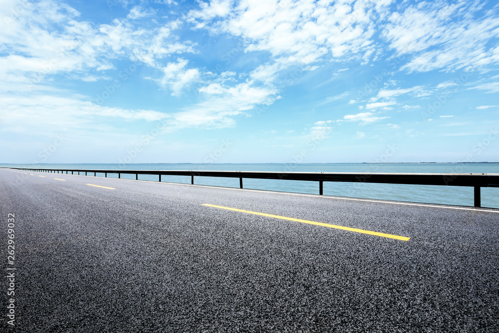Empty asphalt road and sea with beautiful clouds