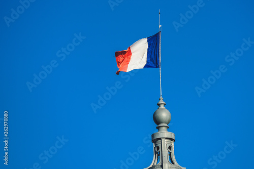 French flag flies on top of an historical building
