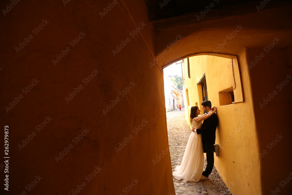 Beautiful wedding couple posing on old narrow street