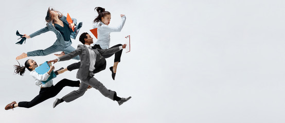 Happy business women and african man dancing isolated on white.