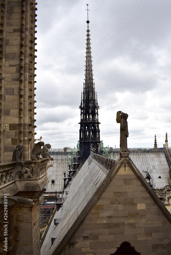Notre Dame Spire, La Fleche, and lead clad wooden roofs before the fire. View of the Apostles, angel statue, chimeras and gargoyles. Paris, France.