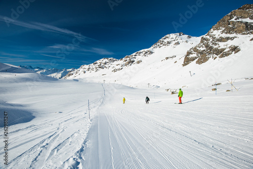 Skiers on a piste in alpine ski resort