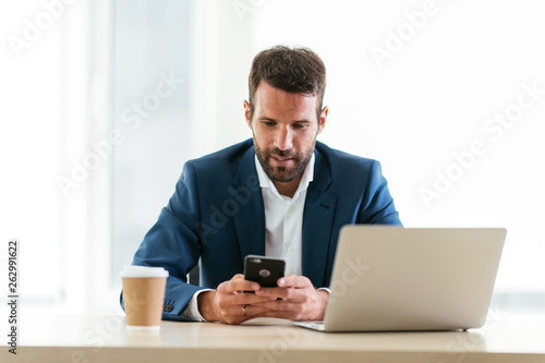 Man sitting at his desk working. Manager on the phone while sitting at his desk. Office worker on his phone.