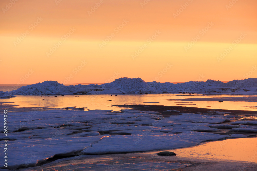 Snow and ice on north sea at sunset