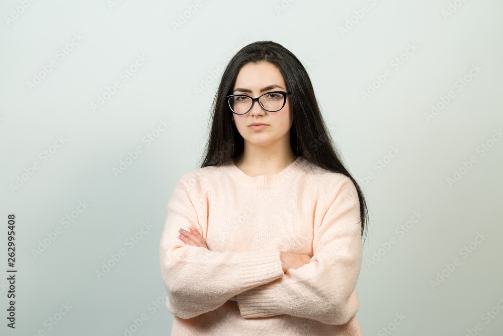 Fototapeta premium Emotional portrait of a dark-haired girl on a gray background, stormy emotions, business concept. 