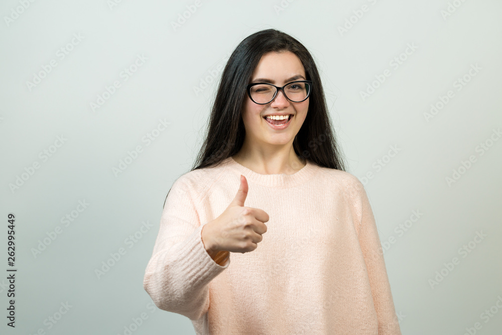 Emotional portrait of a dark-haired girl on a gray background, stormy emotions, business concept. Emotional portrait of a dark-haired girl on a gray background, stormy emotions, business concept.