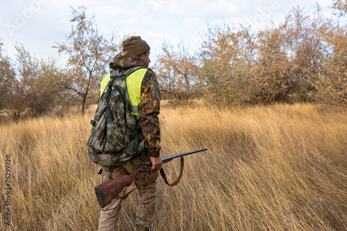 Hunter with a german drathaar and spaniel, pigeon hunting with dogs in reflective vests 