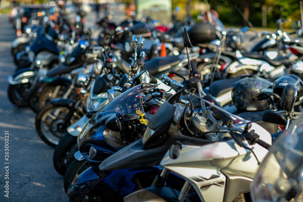 Front wheels of motorcycles exposed in a parking lot. Several parked motorcycles. Front wheels of motorcycles exposed in a parking lot. Several parked motorcycles.