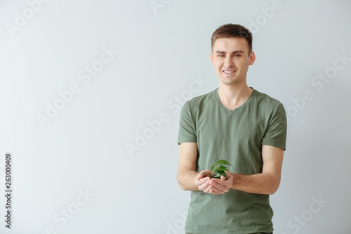 Man with young plant on lig...