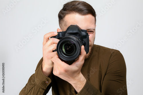 Male photographer on light background