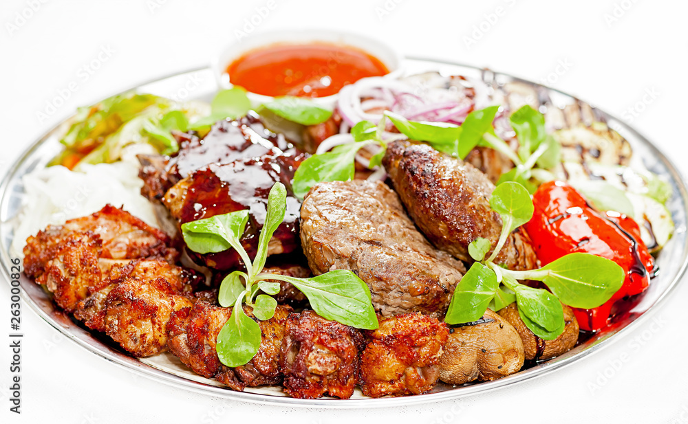A plate with meat dishes, kebabs, bishtex, sauces and various croutons.