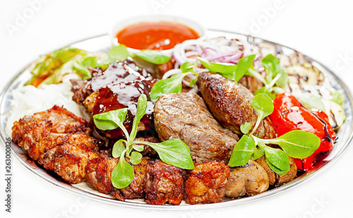 A plate with meat dishes, kebabs, bishtex, sauces and various croutons.