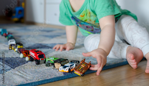 Kid lining up toys on the floor.