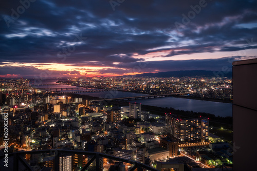 Magic Sunset View over Osaka City with bridges over Yodo River from the top of the Umeda Sky Building in Kasai Region, Japan.