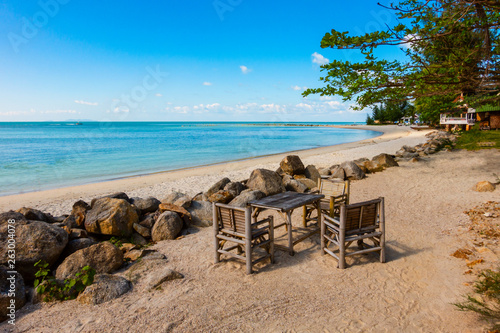 Bamboo chair on the beachblue sea and sky background. © Sloniki