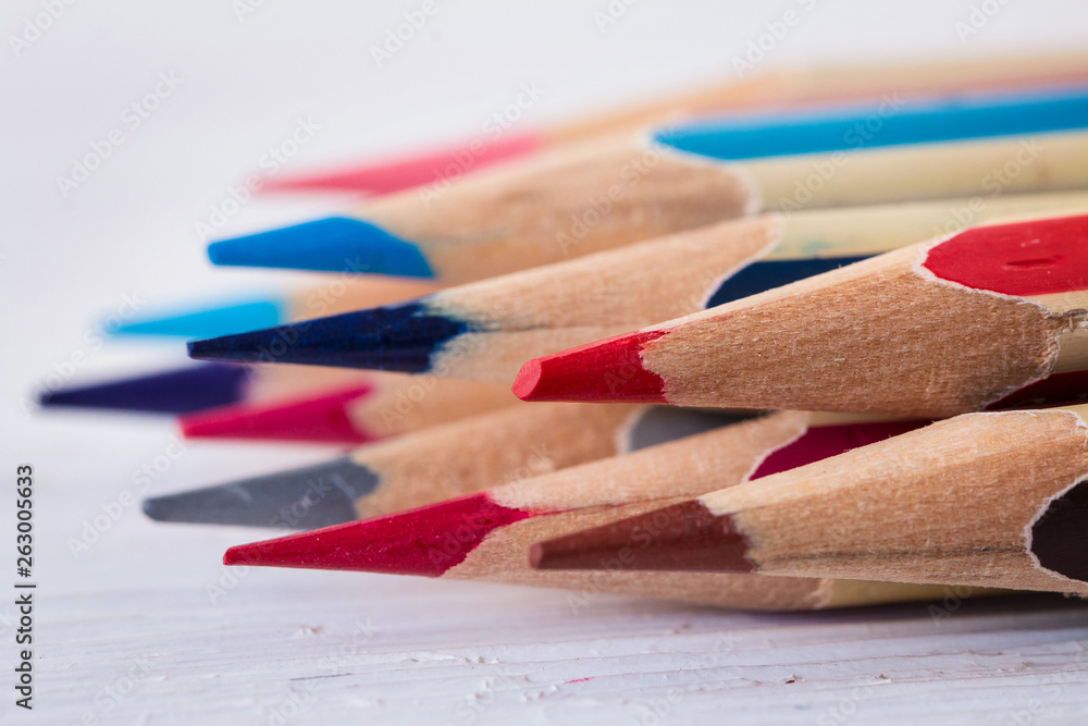 Colored wooden pencils on a white wooden table. Macro. Close up. Side view Colored wooden pencils on a white wooden table. Macro. Close up. Side view