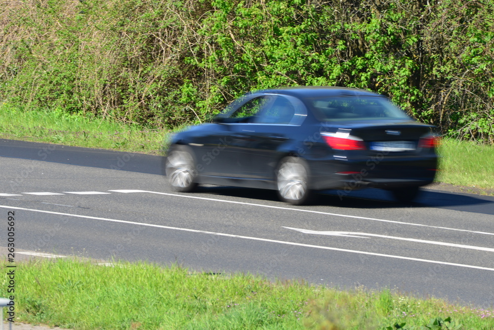 blurred car passing by on a sunny day in europe