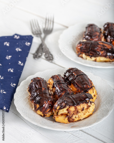 Ekler Pasta / Chocolate Donut in plate on white background. photo