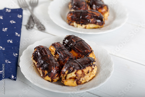 Ekler Pasta / Chocolate Donut in plate on white background. photo