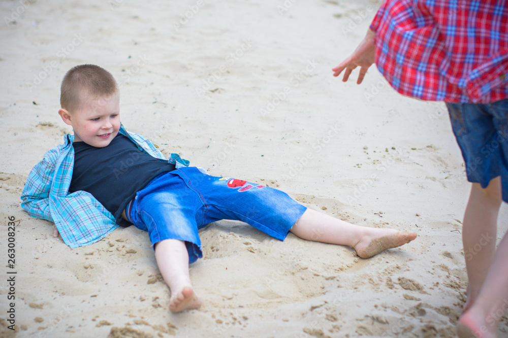 Kids boys playing on a beach near river with water and sand felling happy 