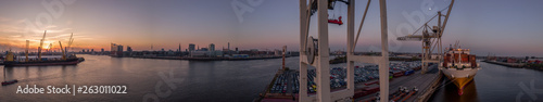 Panorama von Hamburg bei schönen Sonnenuntergang mit Elbphilharmonie und Containerschiff