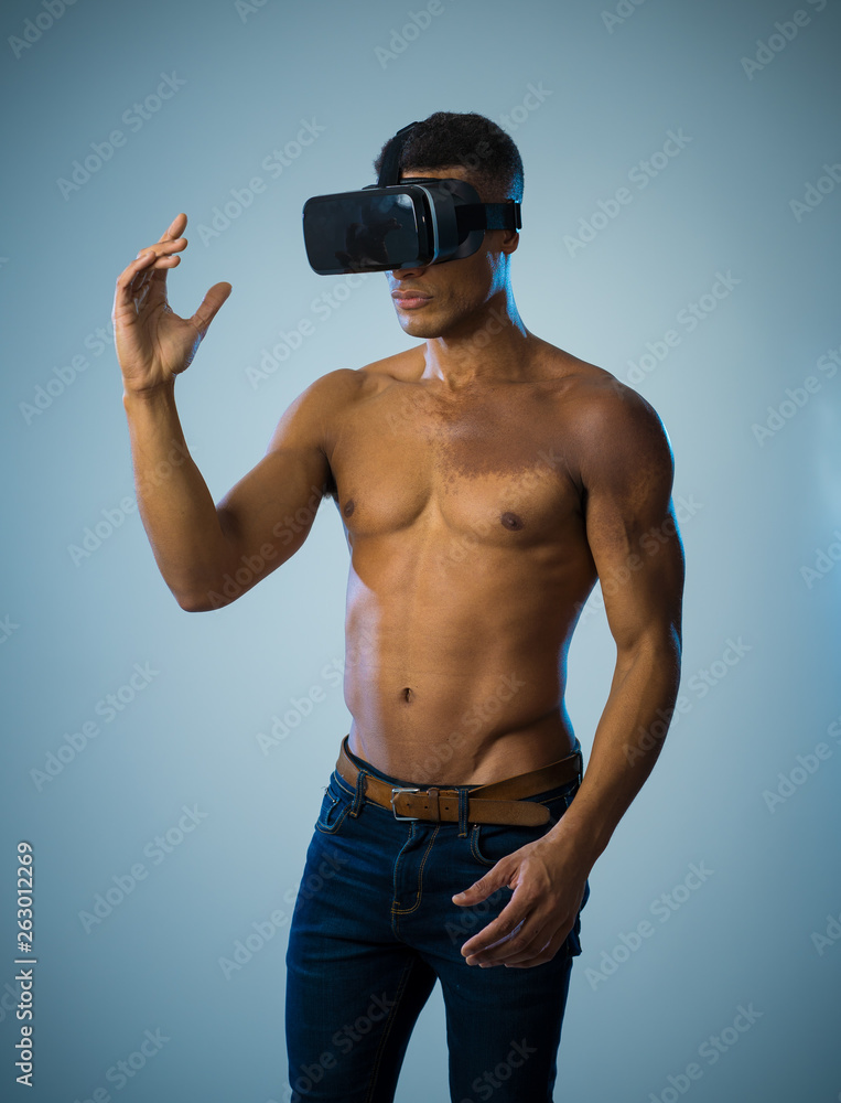 Sexy young african man wearing Virtual Reality headset exploring 3D experiences Sexy young african man wearing Virtual Reality headset exploring 3D experiences
