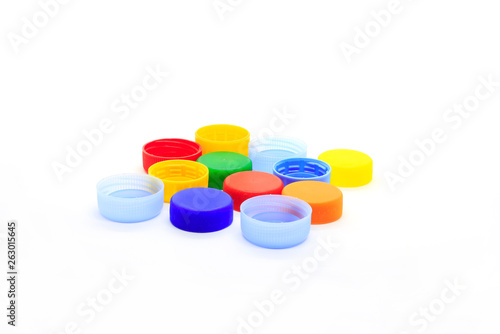 Multicolored caps from plastic bottles on white background