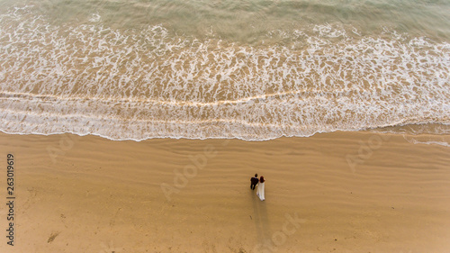 Happy wedding couple posing on beach