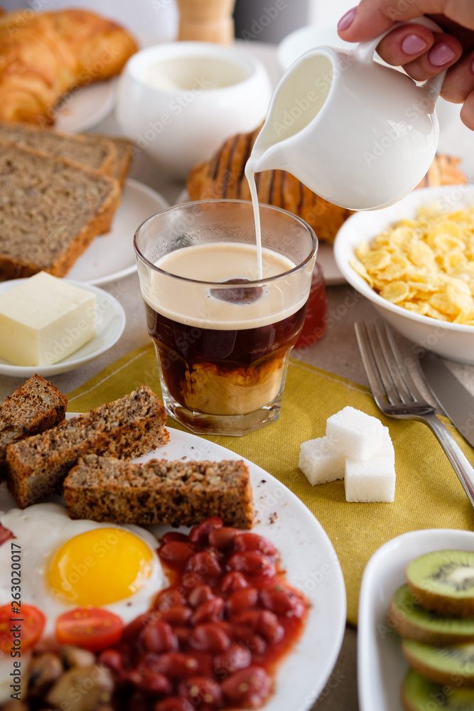 Mug of coffee on the table with English breakfast and croissant Mug of coffee on the table with English breakfast and croissant