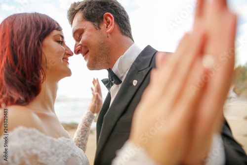 Happy wedding couple posing outdoor near beach