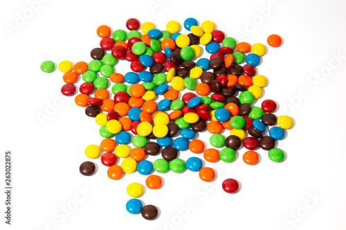 Obraz na plátně Colorful chocolate MMs in and out of focus on white background