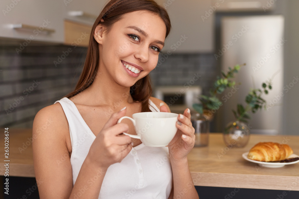 Smiling female having coffee for breakfast Smiling female having coffee for breakfast