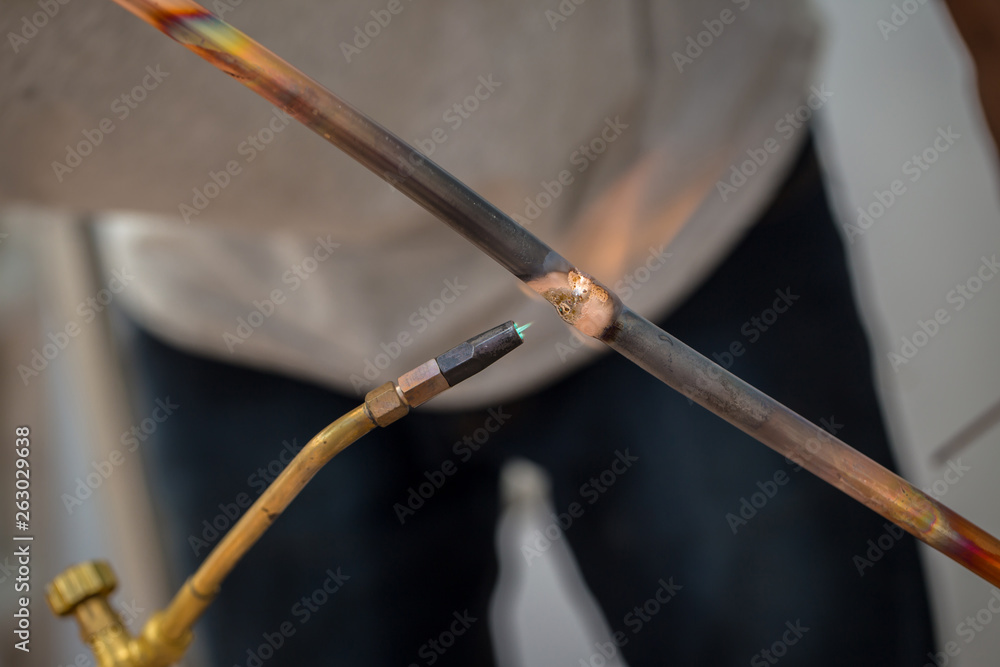Welding of copper pipe of a methane gas pipeline or of a conditioning or water system. Welding soldering copper pipes. Gas Welding Pipe brass contractor air con mechanic Outdoors.