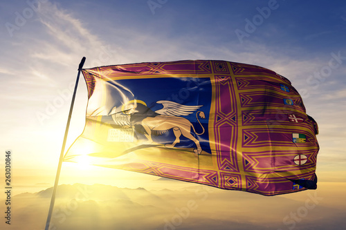 Veneto region of Italy flag waving on the top sunrise mist fog
