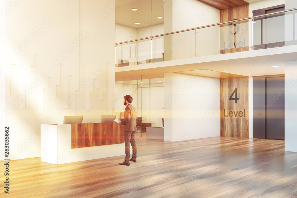 Fototapeta premium Man in office lobby with elevator and reception
