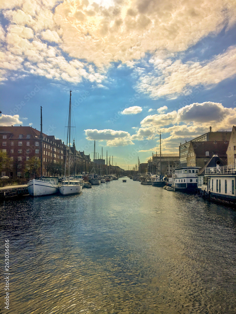 Cumulus in the sky over the city. Reflection of clouds in a water channel. Copenhagen.