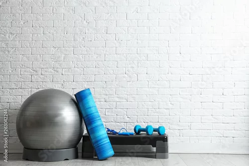 Obraz Zestaw ekwipunku fitness na podłodze w pobliżu mur z cegły. Miejsce na tekst