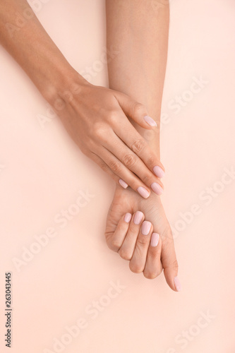 Closeup view of woman with beautiful hands on color background. Spa treatment