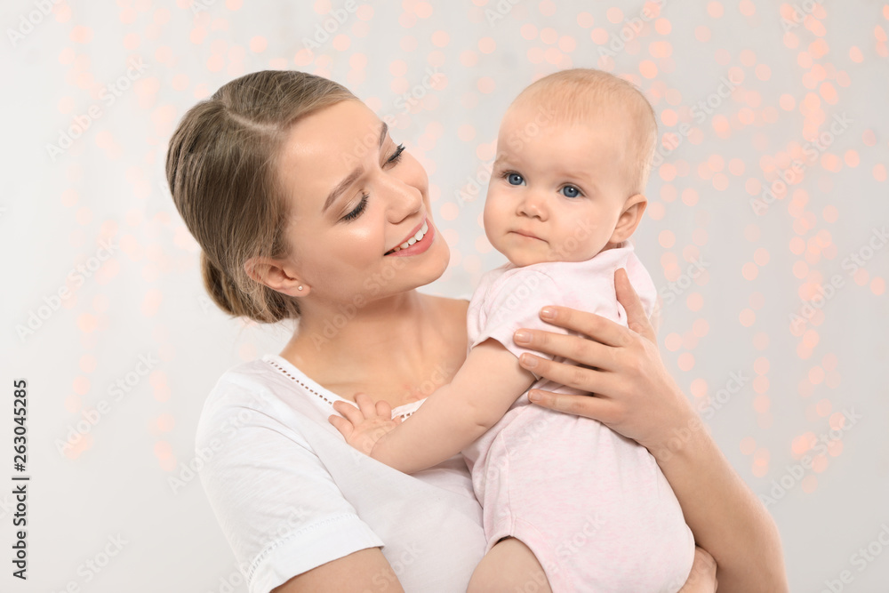 Portrait of happy mother with her baby against blurred lights Portrait of happy mother with her baby against blurred lights