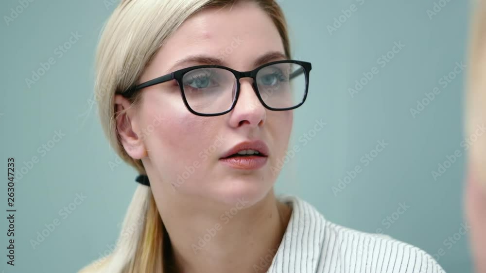 Young woman psychologist in glasses is emotionally talking with her client. Young woman psychologist in glasses is emotionally talking with her client.